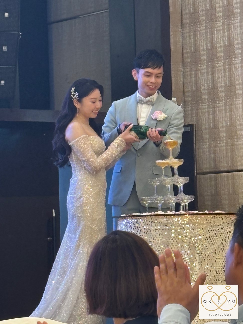 The couple cutting the tiered cake to the guests' cheer